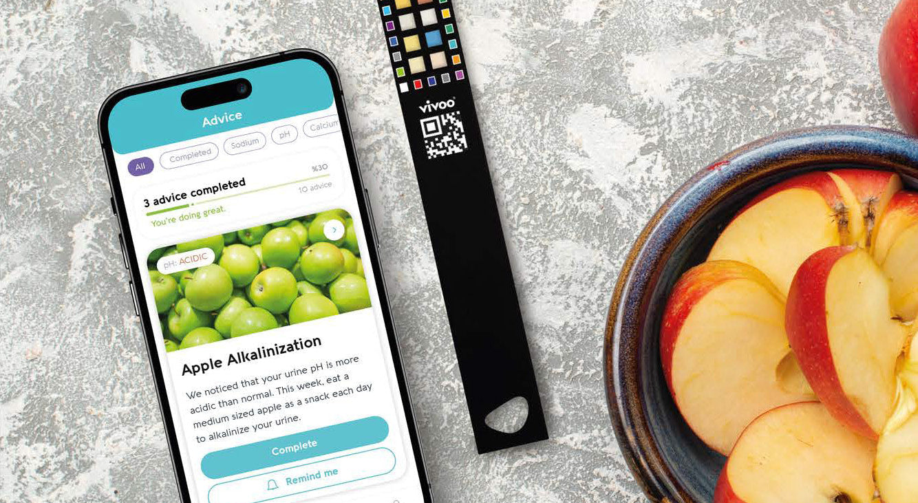 Phone with app on screen, digital scale, and bowl of sliced apples on a textured surface